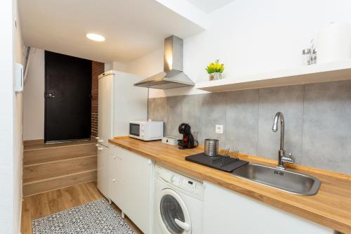 een keuken met een wastafel en een wasmachine bij Apartamento Rauda 51 B, Granada in Granada