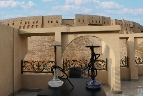 two vases on a table in front of a building at Syros Hotel Erbil City Center in Erbil
