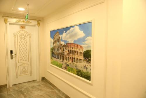 a painting of the colosseum on a wall next to a door at Syros Hotel Erbil City Center in Erbil