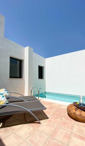 a patio with a table and a swimming pool at B&B Alma do Campo in Olhão