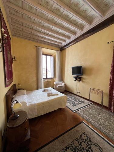 a bedroom with a bed and a tv on the wall at Domus Minervae in Rome