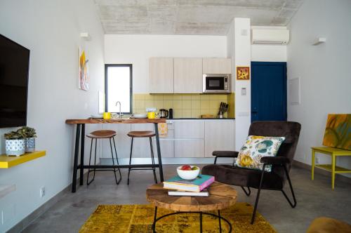 a living room with a table and a kitchen at B&B Alma do Campo in Olhão