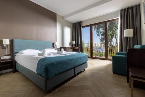 a hotel room with a bed and a balcony at Hotel Meridian in Chałupy