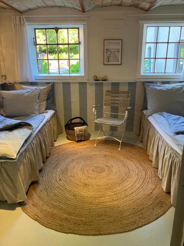 a room with two beds and a chair in it at Porshus Ferielejlighed in Sundstrup