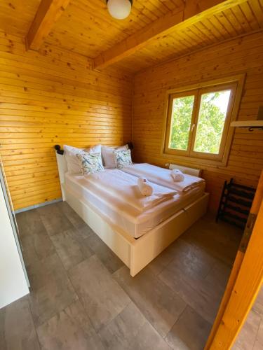 a bedroom with a large bed in a wooden room at Panoráma Faház Mohács in Mohács