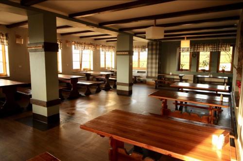 a large room with wooden tables and windows at Schronisko PTTK Hala Szrenicka in Szklarska Poręba