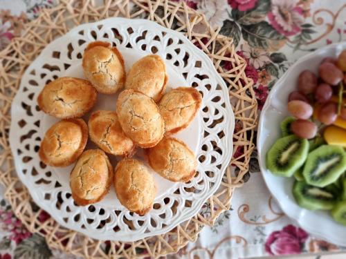a plate of buns on a table with a plate of fruit at Dimora Sole del Sud in Ugento