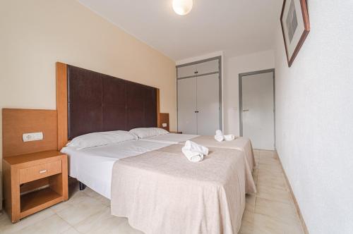 Habitación de hotel con 2 camas con sábanas blancas en El Cortijo Escana en Es Cana
