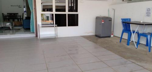 a room with a table and blue chairs and a refrigerator at Homestay Jerantut Sincerelyat in Jerantut