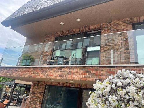 a brick building with a balcony with a bunch of flowers at All Seasons Palanga Apartaments in Palanga