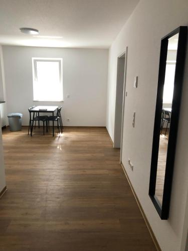 an empty room with a table and a mirror at ApartHotel Roxheim in Roxheim