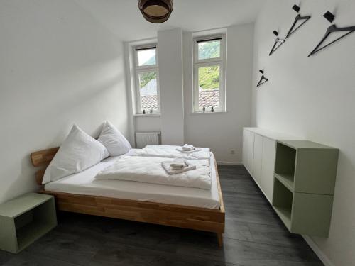 a white bedroom with a bed and two windows at Direct Moselle view 200m² 4 SZ 10Pers Terrace in Sankt Aldegund