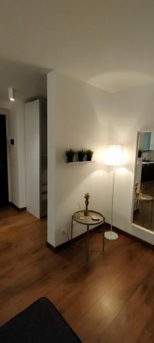 a living room with a table and a lamp at Rododendro 10 in Tarvisio