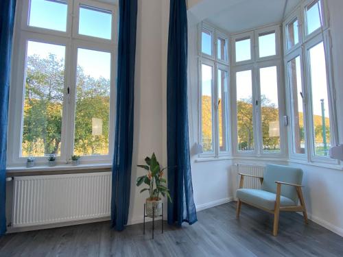 a room with windows and a chair and a plant at Direct Moselle view 200m² 4 SZ 10Pers Terrace in Sankt Aldegund