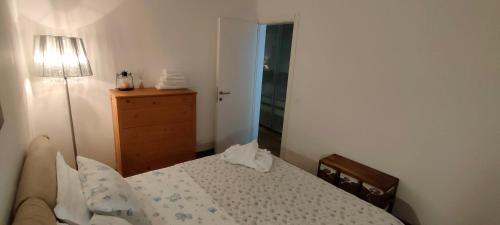- une chambre avec un lit, une commode et une lampe dans l'établissement Rododendro 10, à Tarvisio