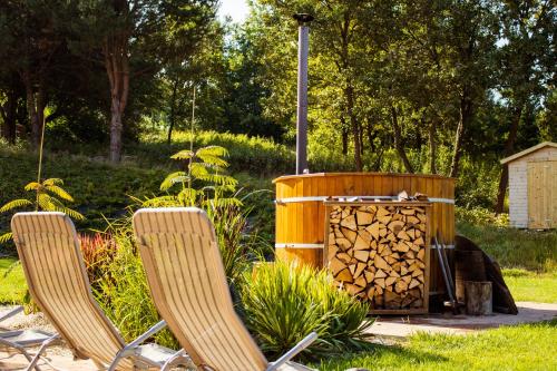 two chairs and a fire pit in a yard at Vendvidéki Pihenőházak in Felsőszölnök