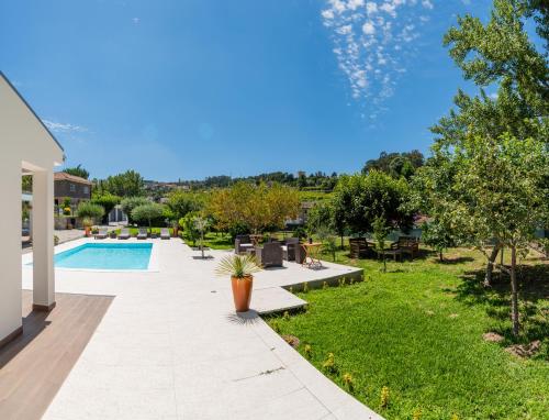 a backyard with a swimming pool and green grass at Villa Casa de Santo Antonio in Marco de Canaveses