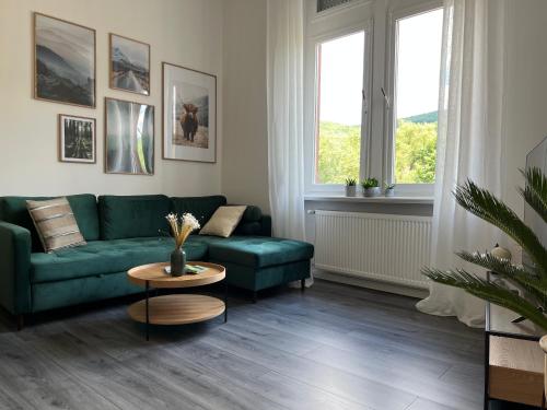 a living room with a green couch and a table at Direct Moselle view 200m² 4 SZ 10Pers Terrace in Sankt Aldegund