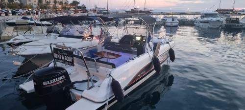 a white boat is docked in the water at Villa Palladium in Makarska