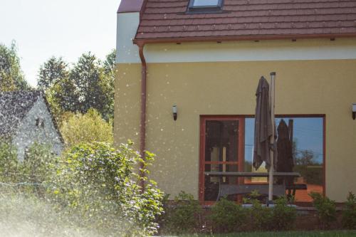 a house with a window and an umbrella on the porch at Vendvidéki Pihenőházak in Felsőszölnök