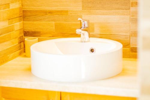 a white sink in a bathroom with wooden walls at Vendvidéki Pihenőházak in Felsőszölnök