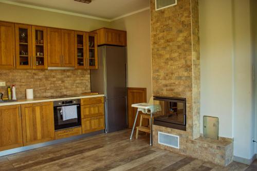 a kitchen with wooden cabinets and a brick wall at Vendvidéki Pihenőházak in Felsőszölnök