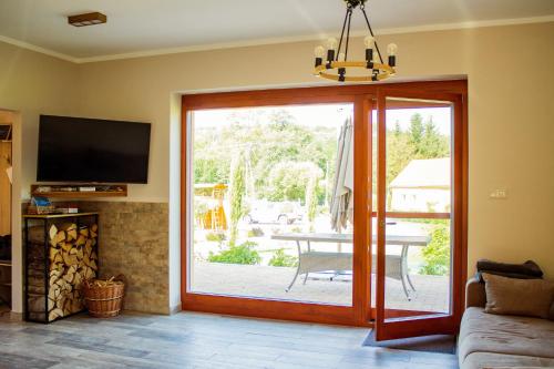 a living room with a sliding door to a patio at Vendvidéki Pihenőházak in Felsőszölnök