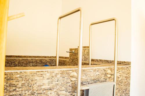 a bathroom with three mirrors on a brick wall at Vendvidéki Pihenőházak in Felsőszölnök