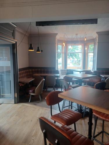 a restaurant with tables and chairs and windows at Ravelston House in Musselburgh