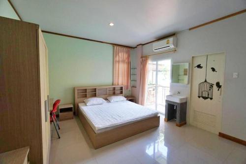 a bedroom with a bed and a sink and a window at Baan Malee in Phuket Town