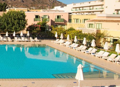 a hotel swimming pool with lounge chairs and umbrellas at Silva Beach Hotel in Hersonissos