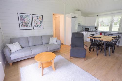 a living room with a couch and a table at Lomaperkkiö Cottages in Kajaani