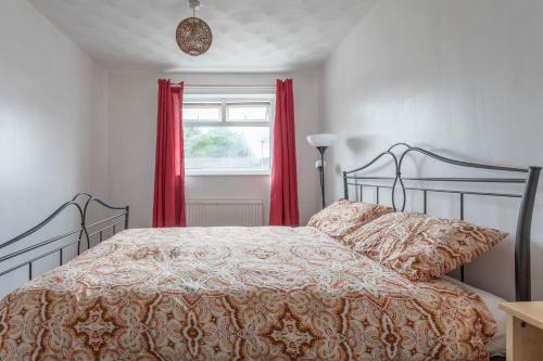 a bedroom with a bed with red curtains and a window at 10 MIN to City Centre R2 in Beeston Hill