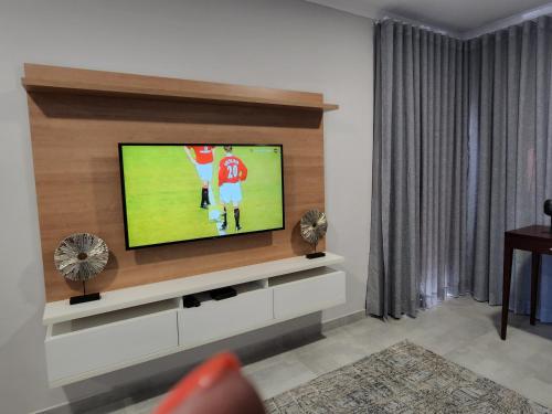a living room with a flat screen tv on a wall at Sarona city Habitat Alpha apartments C202 Gaborone in Gaborone