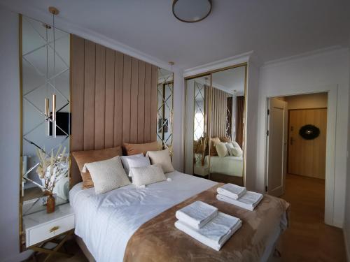 a bedroom with a large bed with towels on it at Gold Apartment B29 Let's Sea Baltic Park Gąski in Gąski