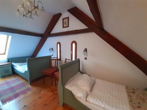 Schlafzimmer im Dachgeschoss mit einem Bett und einem Schreibtisch in der Unterkunft Fény-Szer Vendégház Őrség in Szentgotthárd