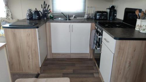a kitchen with a sink and a counter top at Deluxe 3 Bedroom Caravan with extra en-suite North Shore in Skegness