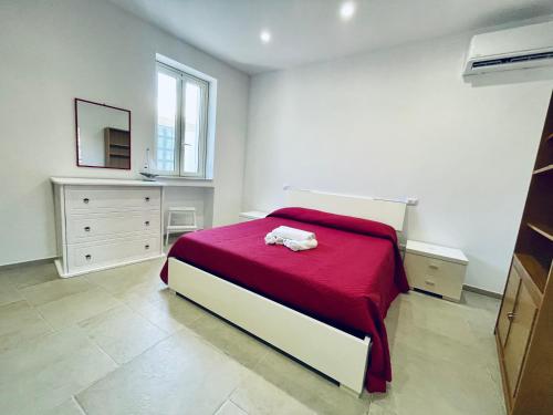a bedroom with a bed with a red blanket at A 2 passi dal mare Torre Faro LA PUNTA SeaHouse in Torre Faro
