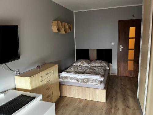 een slaapkamer met een bed en een bureau met een televisie bij Apartament Nadmorski w Świnoujściu in Świnoujście