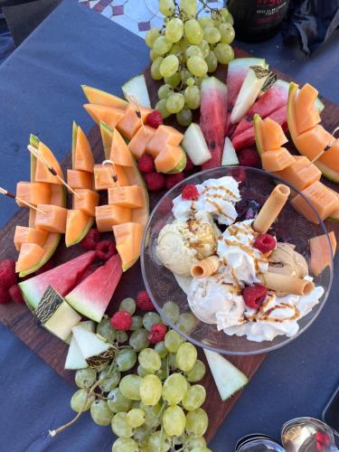a table topped with a plate of cheese and fruit at Tropic Hôtel in Rivesaltes