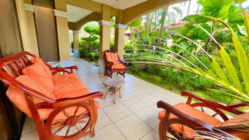 a porch with orange chairs and plants on it at Monte Carlo Luxury Condominiums in Jacó