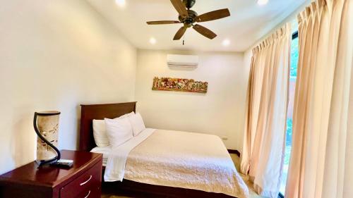 a bedroom with a bed and a ceiling fan at Monte Carlo Luxury Condominiums in Jacó