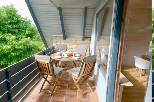 een patio met een tafel en stoelen op een balkon bij Frühlingsbogen in Harrislee