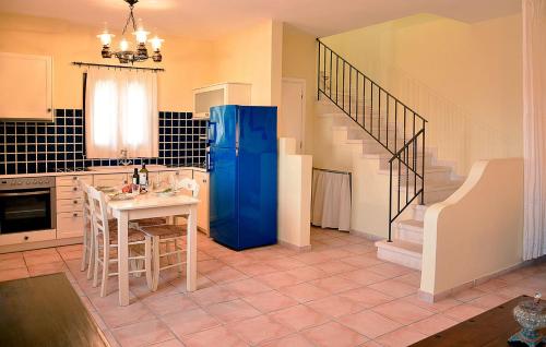 a kitchen with a blue refrigerator and a table at Olive Coast Suites in Palekastron