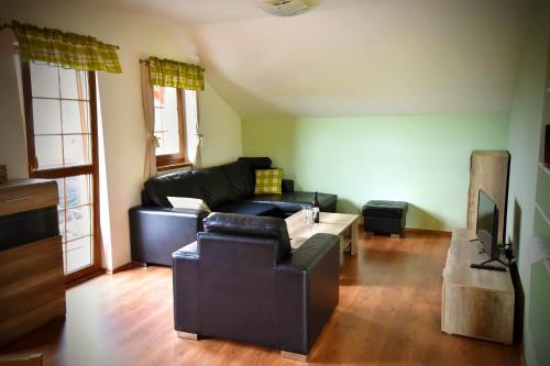 a living room with a black couch and a table at Apartmán Restaurace 16 