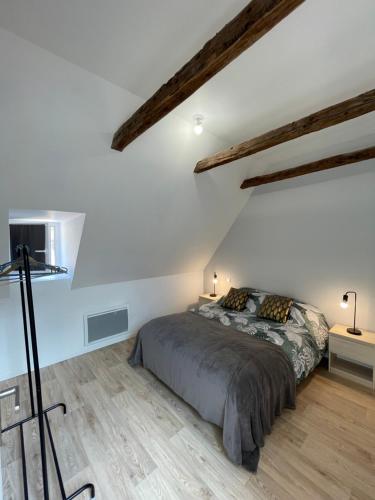 a bedroom with a bed in a room with wooden floors at La loge d’Evelyne in Villecomtal