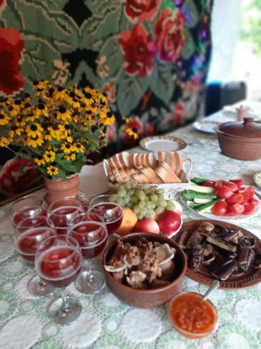 una tavola con piatti di cibo e bicchieri di vino di Pensiunea turistica "Casa rustica" a Chişcăreni