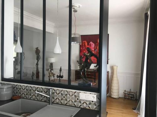 - une cuisine avec un miroir au-dessus d'un évier et d'un comptoir dans l'établissement Maison de caractère en centre ville, à Vichy