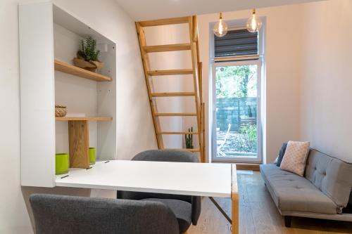 a living room with a table and chairs and a ladder at Cozy studio, private garden, 8 min to city center in Vienna