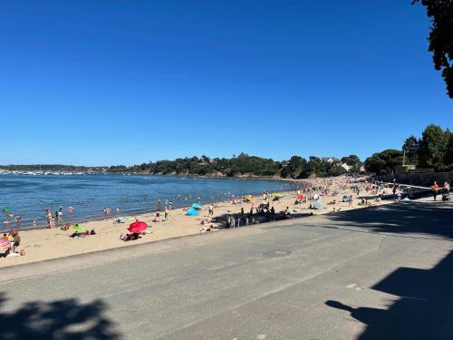 a group of people on a beach near the water at BELLA CRUZ 66 m2 prestations premium, wifi, balcon, parking avec borne de recharge électrique, plage Prieuré, Commerces in Dinard